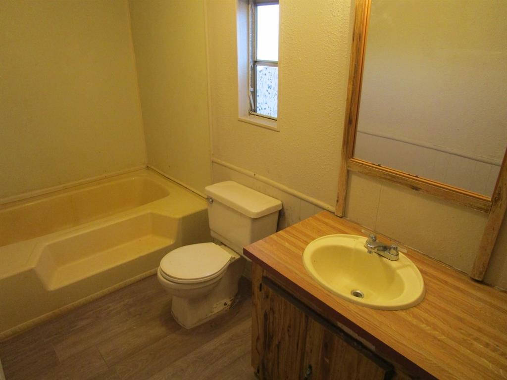 800 Bluff Street Sweetwater, TX 79556 - Photo 19 of 19 a bathroom with a granite countertop toilet and a sink
