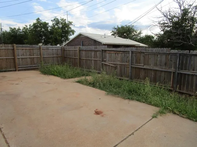 a view of a backyard with wooden fence