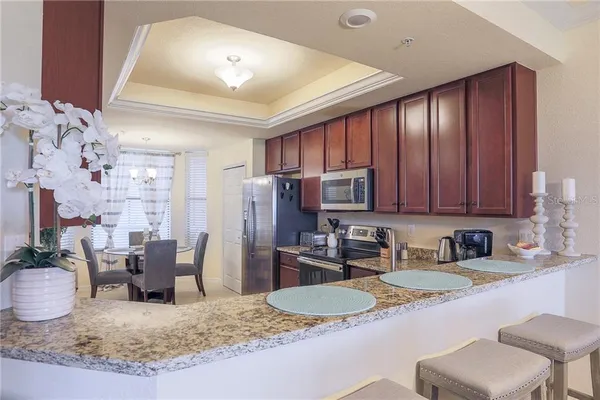 a kitchen with stainless steel appliances granite countertop a sink refrigerator and cabinets