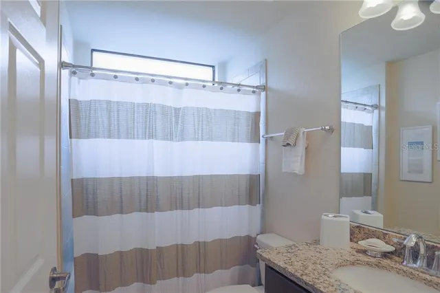a bathroom with a granite countertop shower sink and vanity
