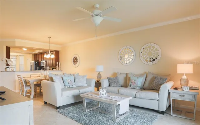 a living room with furniture a clock and a ceiling fan