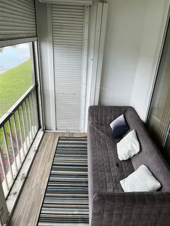 a bedroom with a bed lamp and a large window