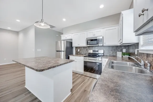 a view of kitchen with cabinets microwave and stove