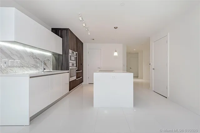 a view of a kitchen with refrigerator and white cabinets
