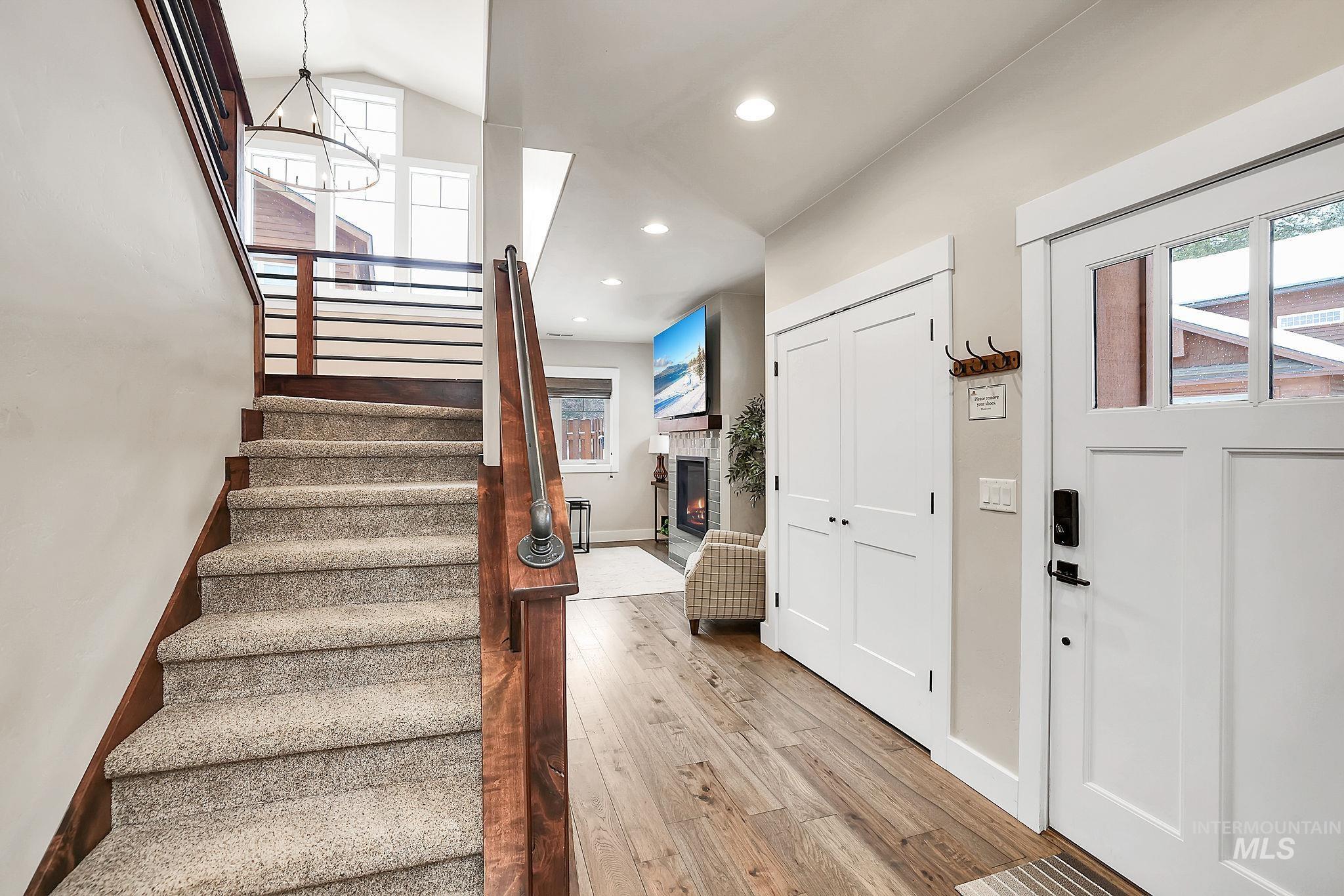 609 Blue Water Circle McCall, ID 83638 - Photo 27 of 45 Entrance foyer featuring light wood-type flooring, a warm lit fireplace, and suspended lighting