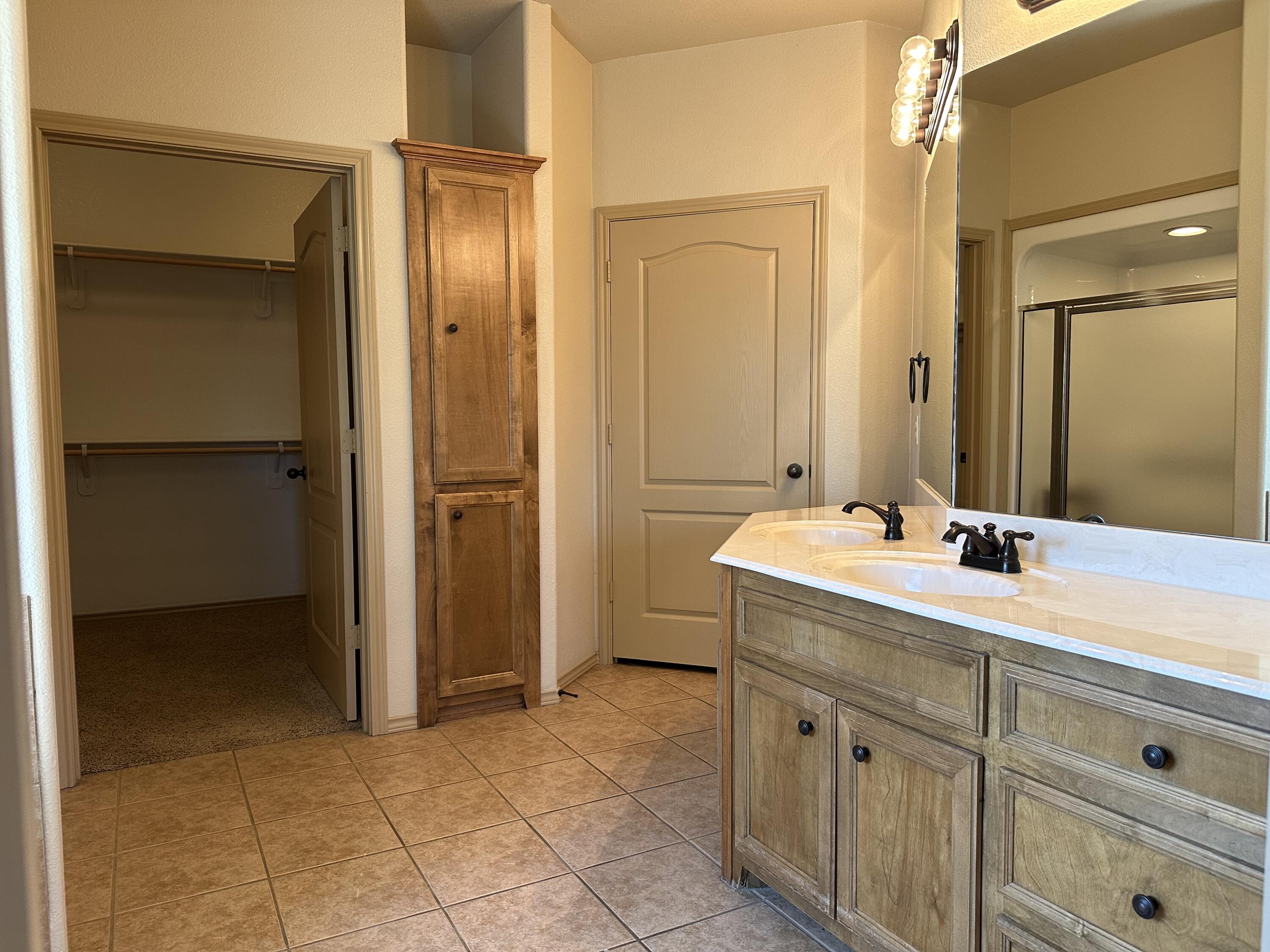 6114 75th Place Lubbock, TX 79424 - Photo 19 of 35 a spacious bathroom with a granite countertop sink and a mirror