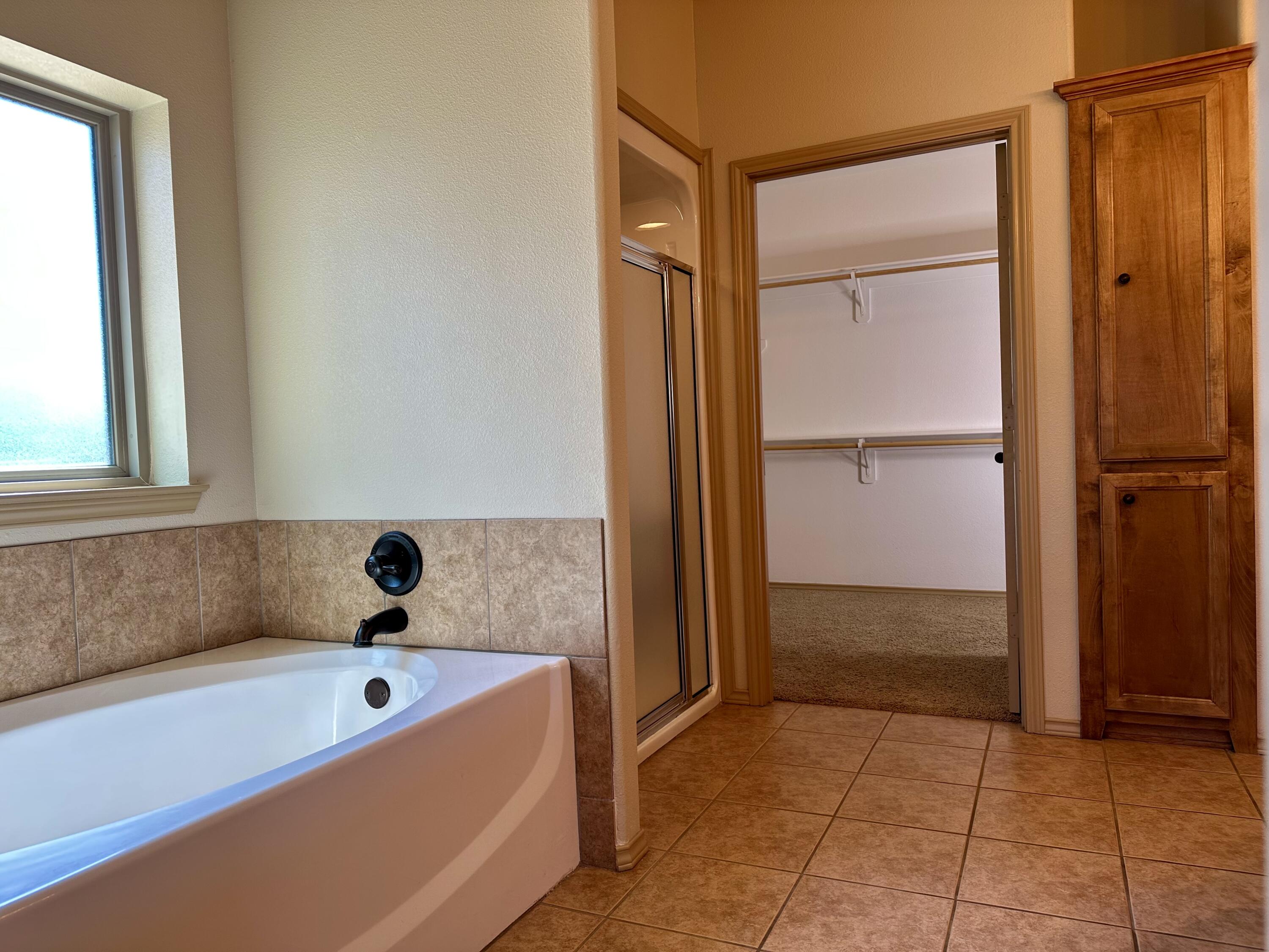 6114 75th Place Lubbock, TX 79424 - Photo 21 of 35 a bathroom with a tub and a shower