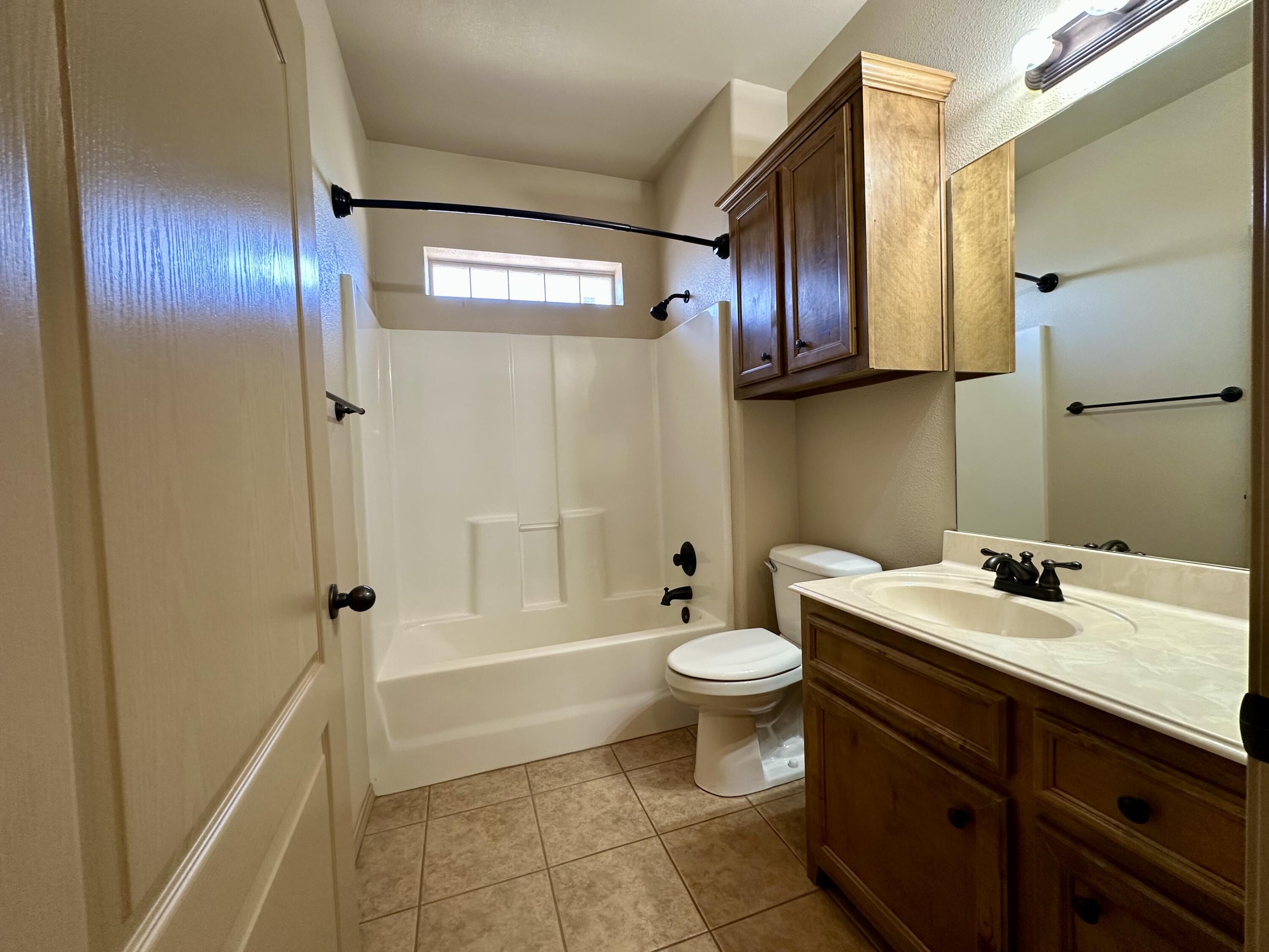 6114 75th Place Lubbock, TX 79424 - Photo 30 of 35 a bathroom with a sink a toilet and shower