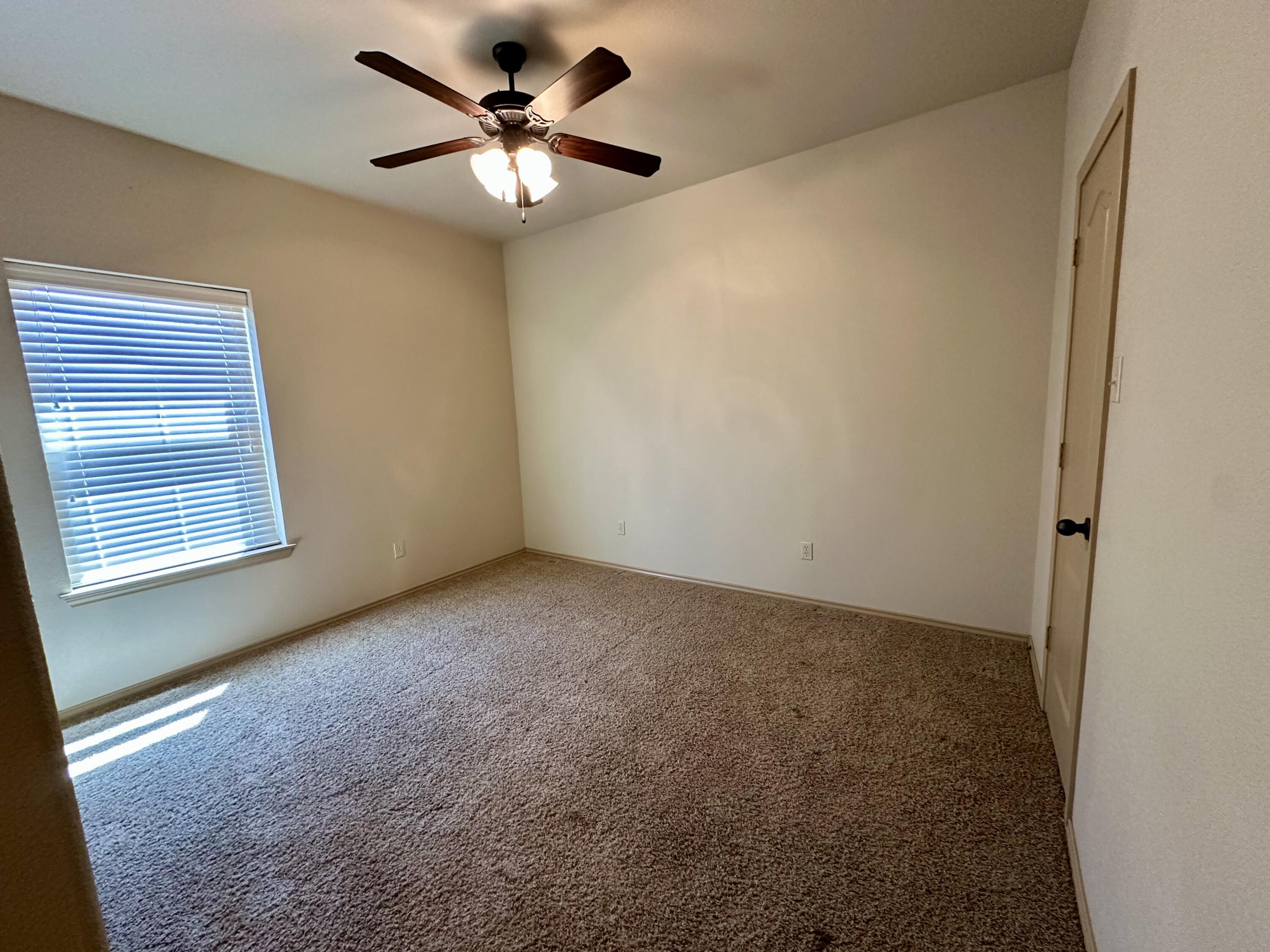 6114 75th Place Lubbock, TX 79424 - Photo 31 of 35 en empty room with windows and ceiling fan