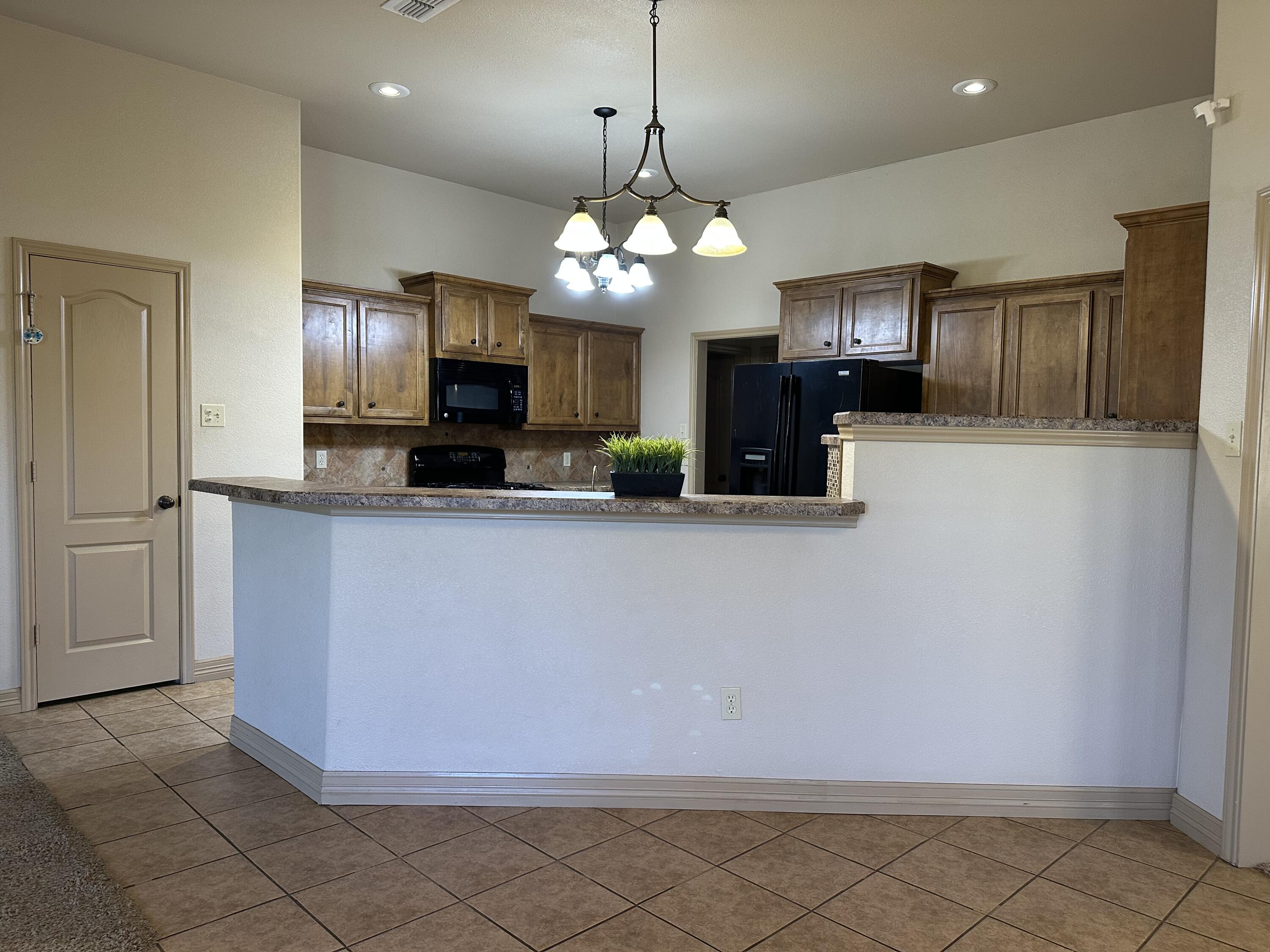 6114 75th Place Lubbock, TX 79424 - Photo 5 of 35 a kitchen with granite countertop cabinets and stainless steel appliances