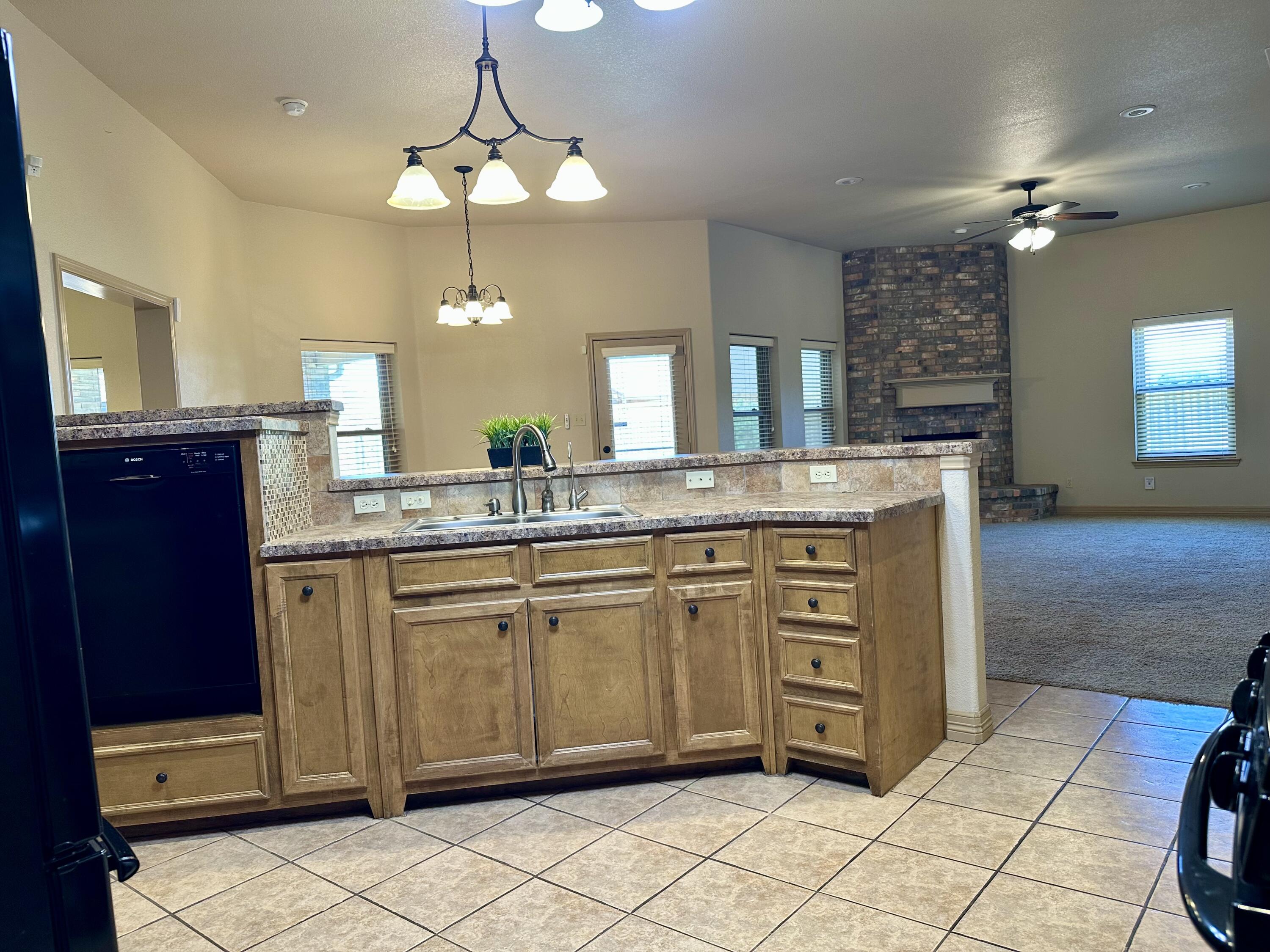 6114 75th Place Lubbock, TX 79424 - Photo 7 of 35 a bathroom with a granite countertop sink a light fixture and a mirror