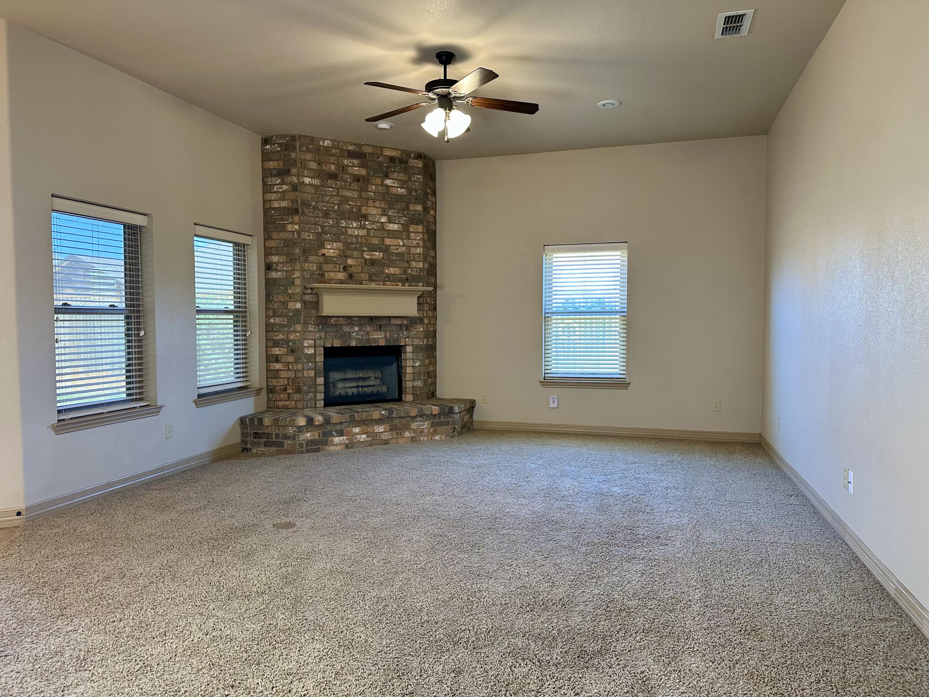 6114 75th Place Lubbock, TX 79424 - Photo 8 of 35 an empty room with windows and fireplace
