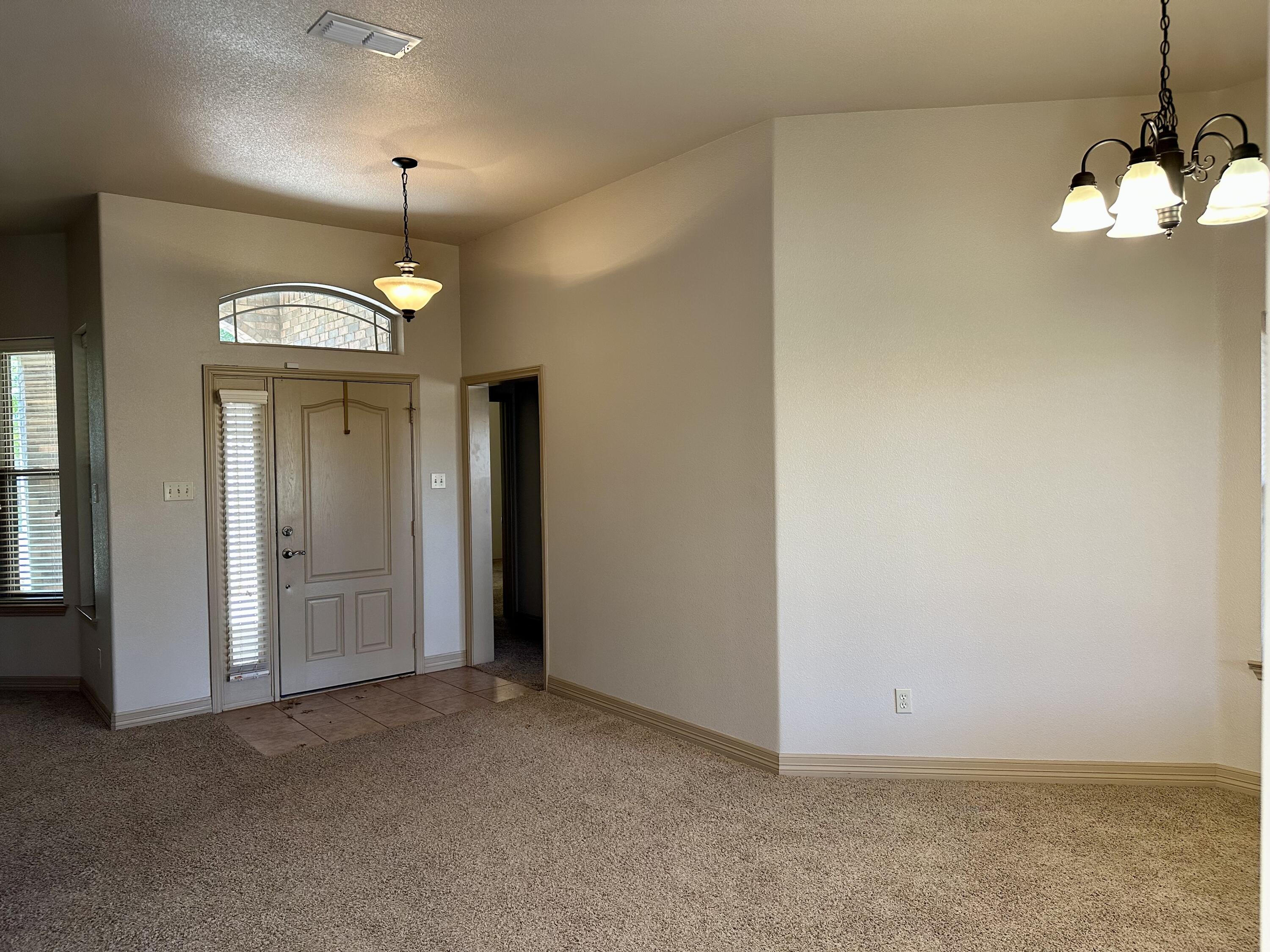 6114 75th Place Lubbock, TX 79424 - Photo 10 of 35 an empty room with a mirror and a window
