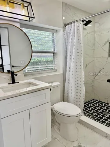 a bathroom with a sink toilet a shower and a mirror