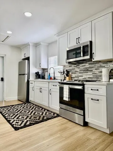 a kitchen with stainless steel appliances granite countertop a stove and a refrigerator