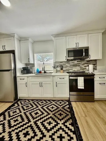 a kitchen with a sink stove and refrigerator