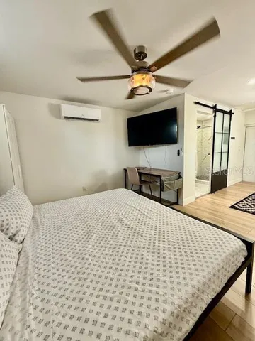 a bedroom with a bed and a flat screen tv