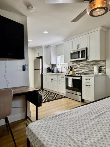 a kitchen with stainless steel appliances a stove a sink a microwave a refrigerator and cabinets