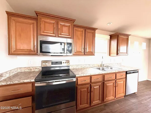 a kitchen with stainless steel appliances granite countertop a stove microwave and sink