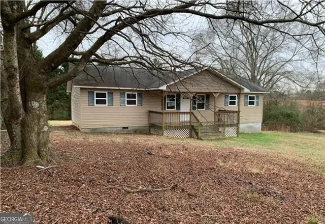 a white house that has a tree in front of it