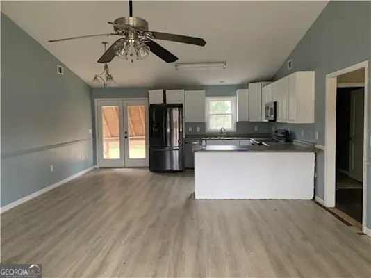 838 Racetrack Road Toccoa, GA 30577 - Photo 4 of 7 a kitchen with stainless steel appliances granite countertop a refrigerator a stove a microwave and white cabinets with wooden floor