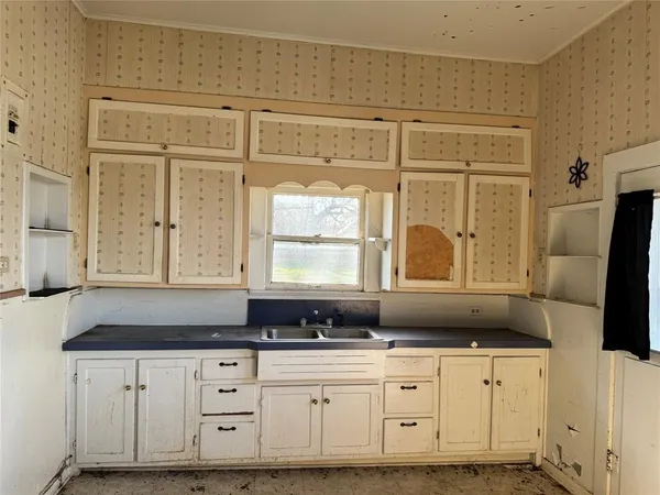 a kitchen with granite countertop white cabinets and sink