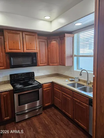 a kitchen with granite countertop a refrigerator stove and microwave