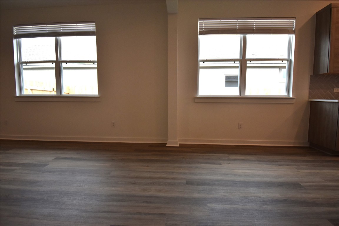 18113 Emu Lane Manor, TX 78653 - Photo 5 of 20 an empty room with wooden floor and windows