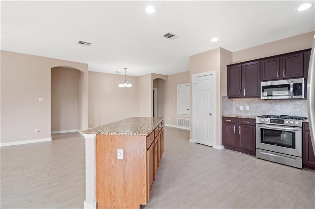 20224 Merlin Falcon Trail Pflugerville, TX 78660 - Photo 22 of 40 Culinary delights await in this modern kitchen with granite countertops and abundant cabinet space.