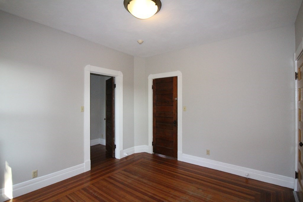 524 Armory Street Springfield, MA 01104 - Photo 11 of 11 a view of an empty room with wooden floor and a window