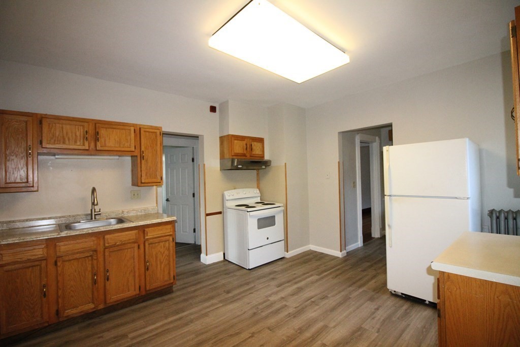 524 Armory Street Springfield, MA 01104 - Photo 2 of 11 a kitchen with a sink a refrigerator a stove and wooden floor
