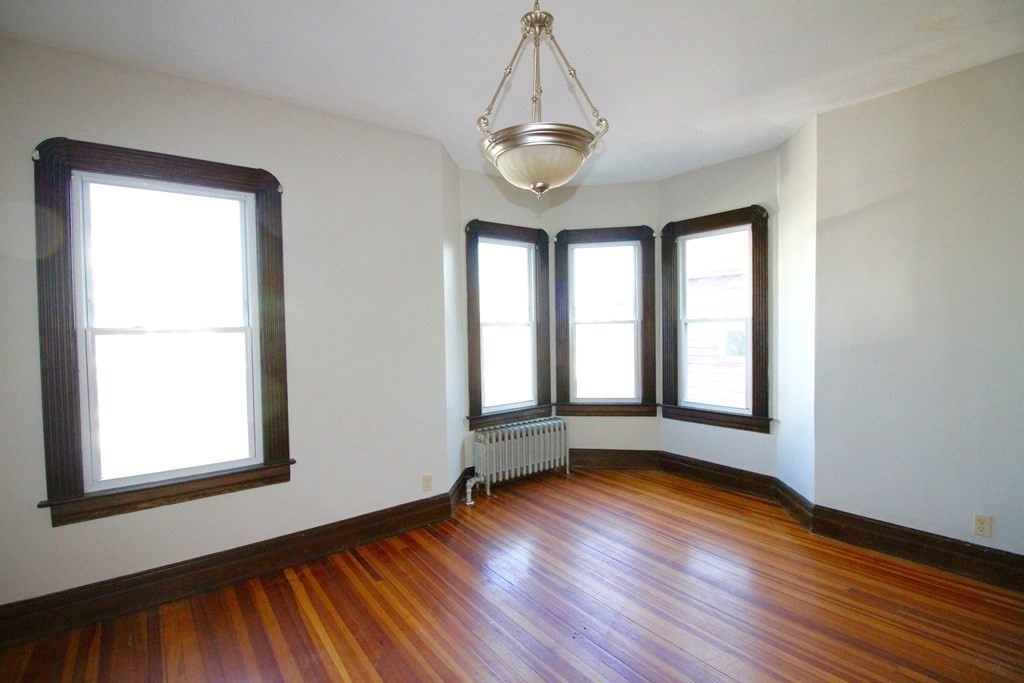 524 Armory Street Springfield, MA 01104 - Photo 7 of 11 a view of an empty room with wooden floor and a window