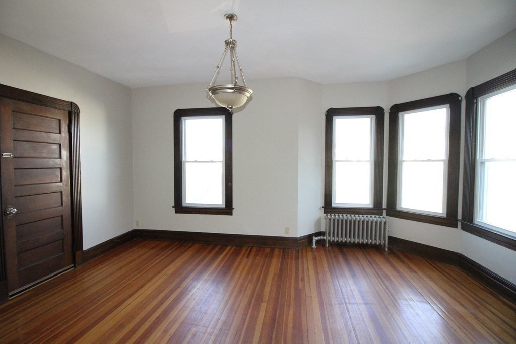 524 Armory Street Springfield, MA 01104 - Photo 8 of 11 an empty room with wooden floor and windows