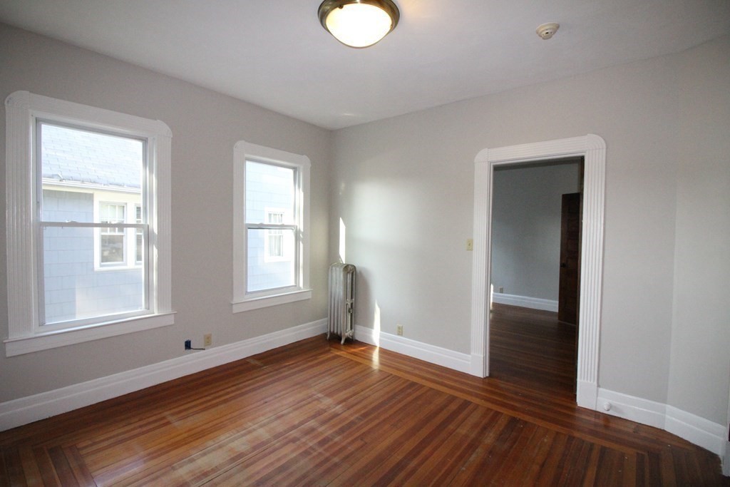 524 Armory Street Springfield, MA 01104 - Photo 9 of 11 an empty room with wooden floor and windows