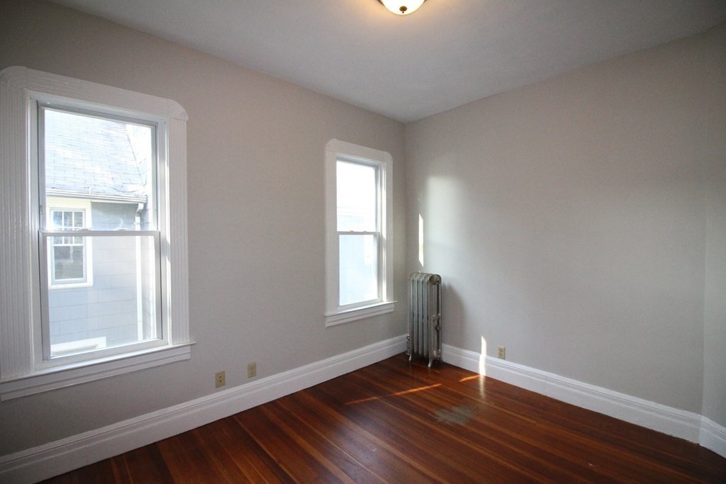 524 Armory Street Springfield, MA 01104 - Photo 10 of 11 an empty room with wooden floor and windows