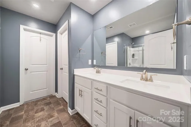 a spacious bathroom with a double vanity sink and mirror