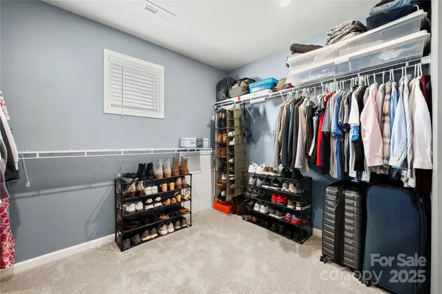 a view of walk in closet with clothes and shoes