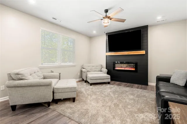 a living room with furniture a flat screen tv and a fireplace