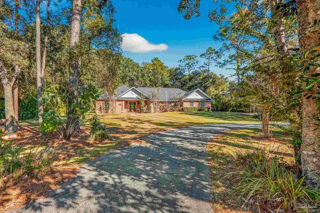 a view of house with yard and swimming pool