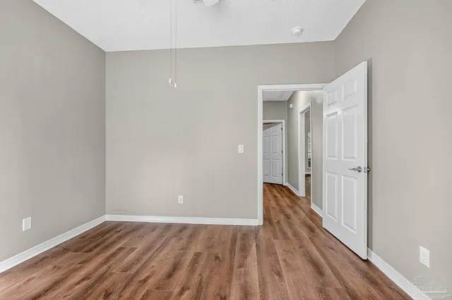 a view of a hallway with wooden floor and closet