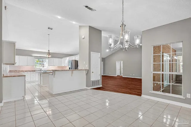 a kitchen with kitchen island granite countertop a sink cabinets and stainless steel appliances