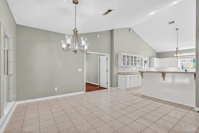 a kitchen with granite countertop white cabinets stainless steel appliances a sink and a window
