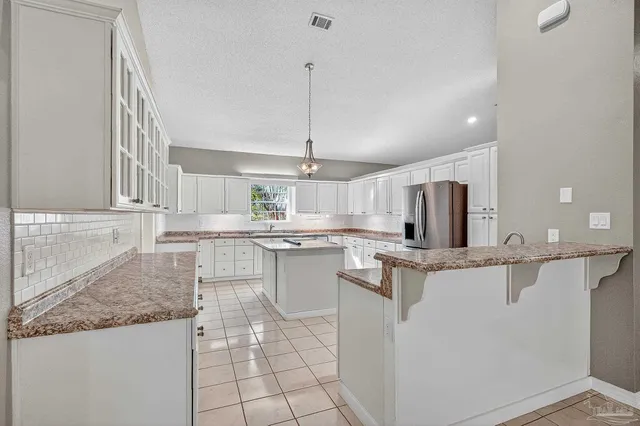 a kitchen with granite countertop a sink a counter top space appliances and cabinets