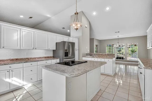 a kitchen with white cabinets and appliances