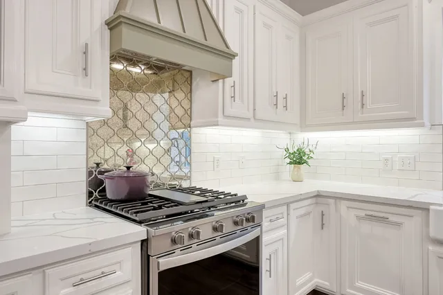 a kitchen with a stove and white cabinets