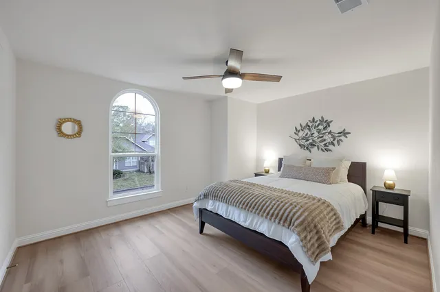 a bedroom with a large bed and a chandelier
