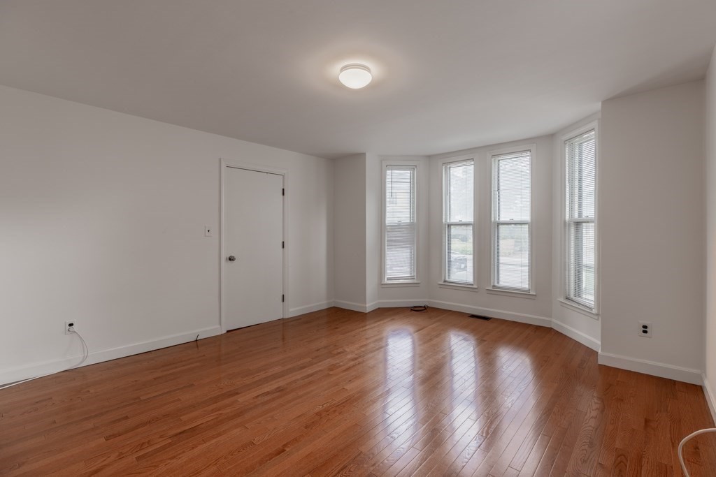 55 Morse Street, Unit 1 Watertown, MA 02472 - Photo 7 of 12 a view of an empty room with wooden floor and a window