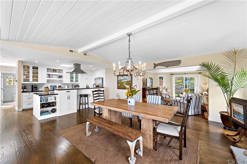 30852 Driftwood Drive Laguna Beach, CA 92651 - Photo 18 of 54 a dining room with wooden floor a chandelier a glass table and chairs