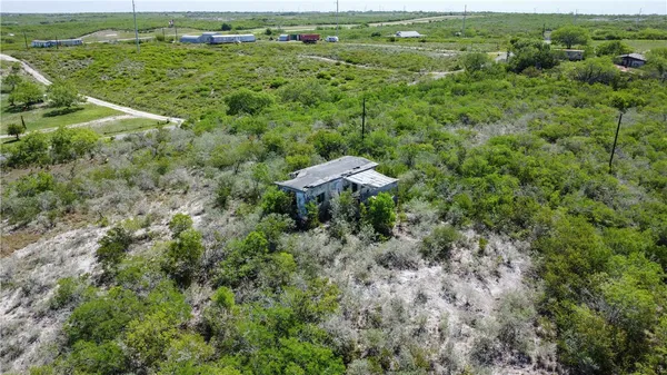 an aerial view of residential houses with outdoor space and trees