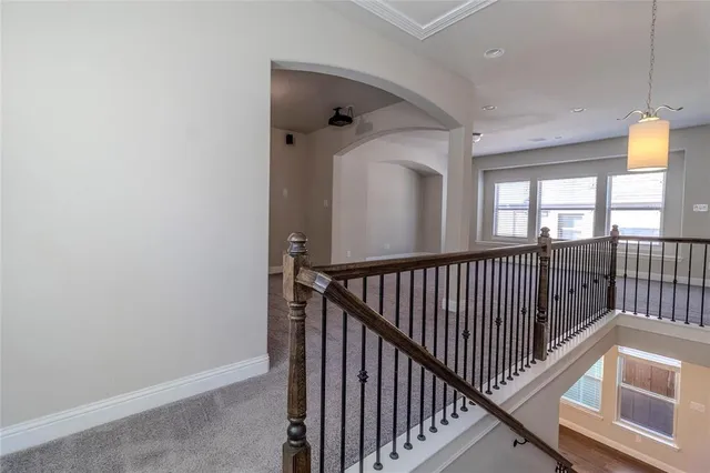 a view of a hallway with wooden floor and stairs